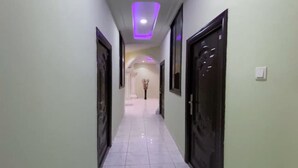 A hallway with doors on both sides, a tiled floor, and a ceiling with recessed lighting. - DJ Villa Your Premium Stay-FF11 (Tema Community 25, Accra-Dawhenya)