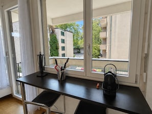 Eine Küchenzeile mit Fenster, schwarzer Arbeitsplatte und einem Korb.