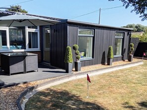 A modern house with a patio, a dining area, and a small garden. - 19 The Court (Skegness)