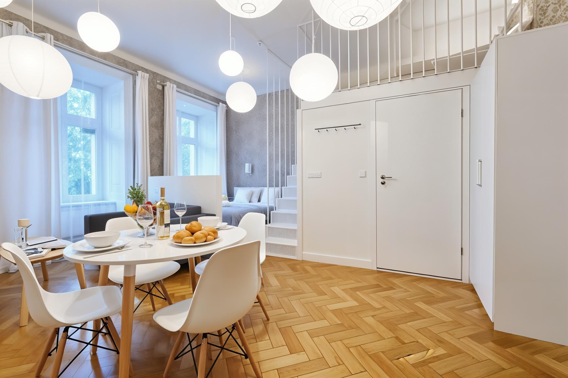 A modern dining area with a round table, white chairs, and pendant lights.