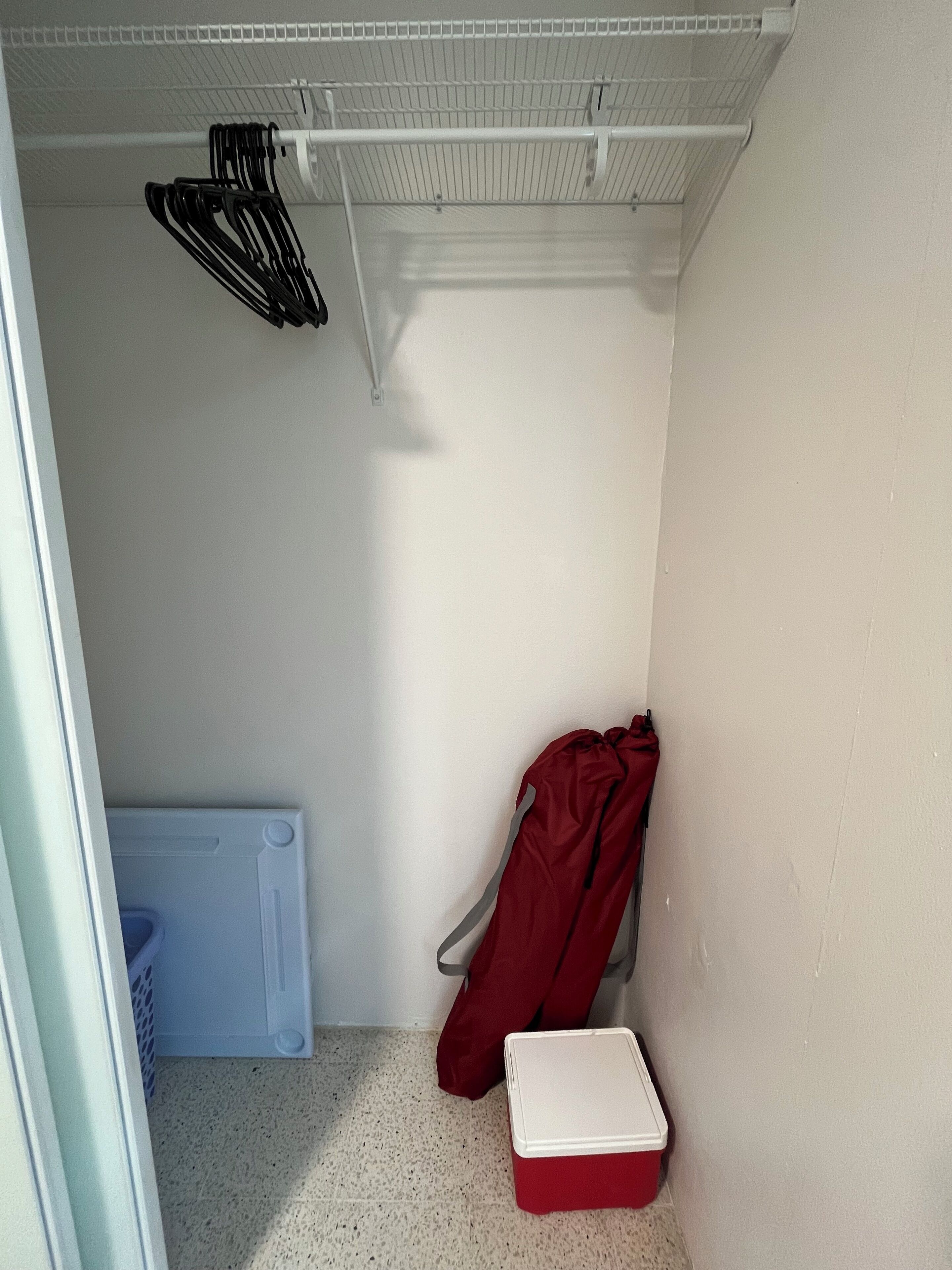 A compact storage area with a white ceiling, a white wall, and a white floor.