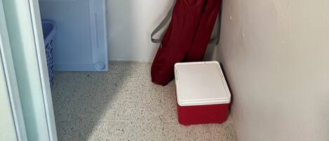 A compact storage area with a white ceiling, a white wall, and a white floor.