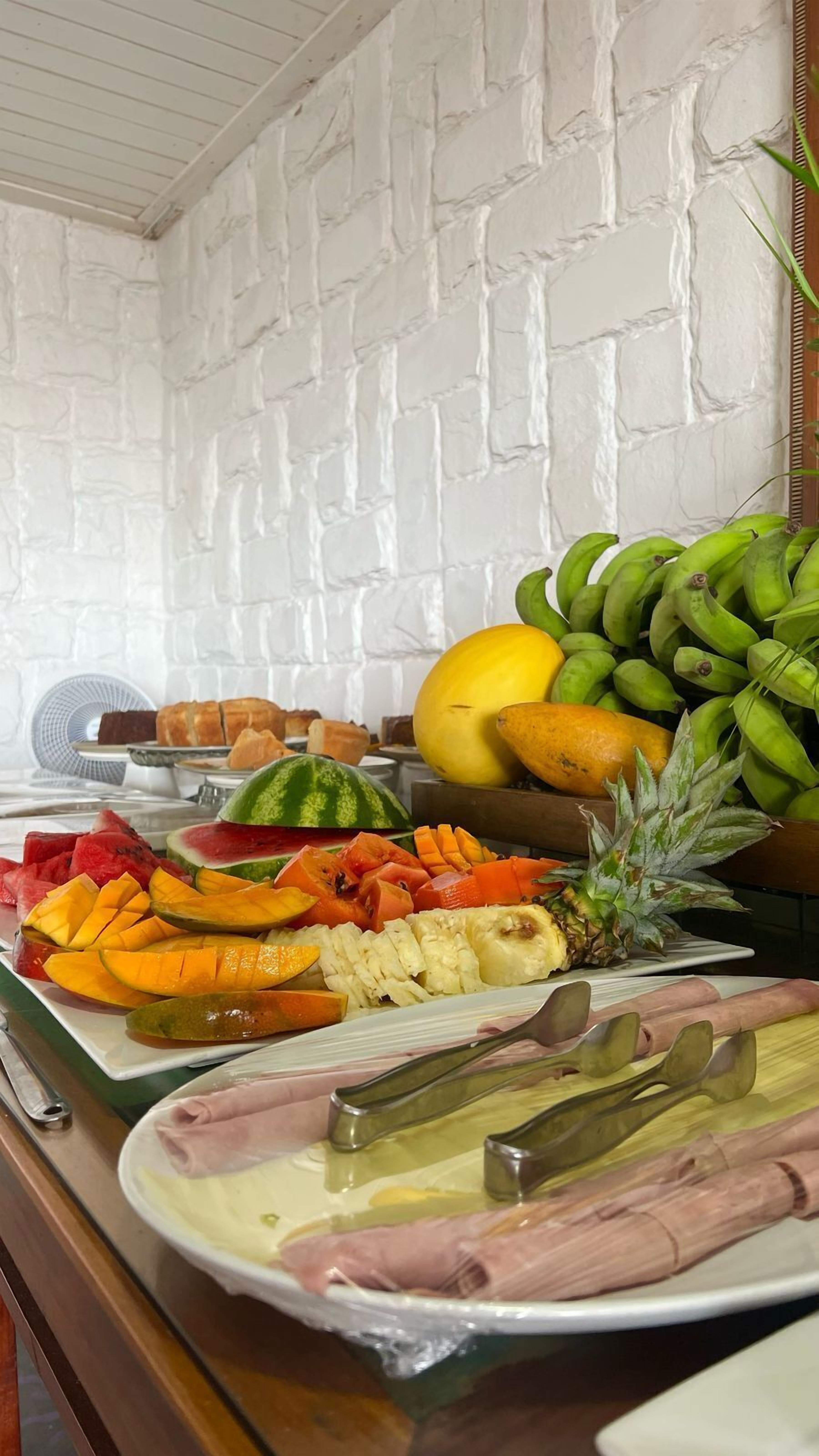 A buffet with various fruits and vegetables, including watermelon, pineapple, and bananas.