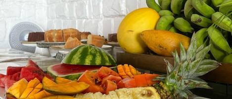 A buffet with various fruits and vegetables, including watermelon, pineapple, and bananas.