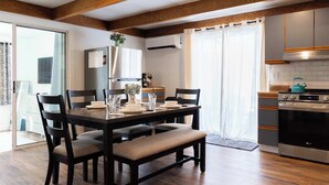 Una cocina moderna con suelo de madera, una mesa de comedor para cuatro personas y un horno LG.
