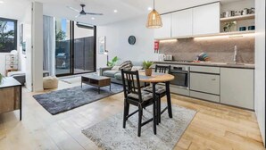 Une cuisine moderne avec un coin repas, un ventilateur de plafond et une grande fenêtre.