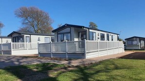 Una hilera de casas móviles con fachadas blancas y un área exterior cercada.