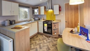 Una cocina compacta con microondas, estufa y armarios de madera.