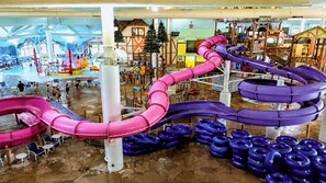 An indoor water park with multiple slides and inflatable rings.