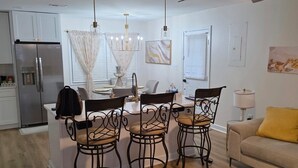 Una cocina moderna con isla integrada, sillas de comedor y ventilador de techo.
