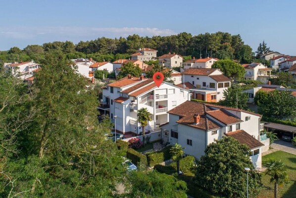 A residential area with white buildings, red-tiled roofs, and lush greenery. - Apartment SoMi 1 (Porec)