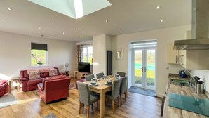 A modern living space with a dining area, kitchen, and seating area.