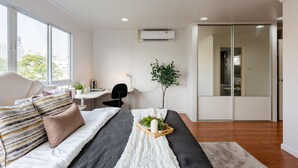 Une chambre moderne avec un lit, un bureau et une vue sur la ville.