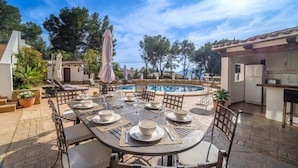 An outdoor dining area with a pool, surrounded by trees and a clear sky. - Casa Andrea 4 bed, 4 bath Villa with pool in Javea (Xàbia)