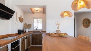 A modern kitchen with wooden cabinets, a built-in oven, and a central island.