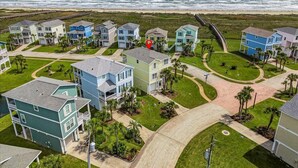 A coastal residential area with houses, a beach, and a boardwalk. - 4/4 - Direct Boardwalk to Beach - Neighborhood Beach Club - Beach Views (Galveston)