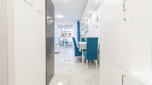 A modern kitchen with white cabinets, a stainless steel refrigerator, and a blue chair. - Modern apartment Marijan  (Makarska)