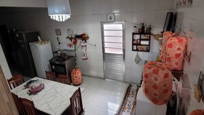Cuina compacta amb zona de menjador, nevera, fogó i finestra.