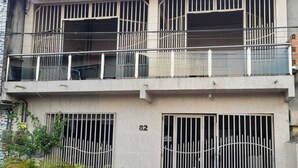 Un edifici de dues plantes amb baranes a les finestres i un balcó.