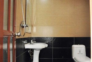 Un baño con lavamanos blanco, inodoro y zona de ducha.