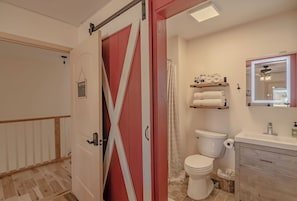 A bathroom with a white toilet, a sink, a mirror, and a shower curtain.