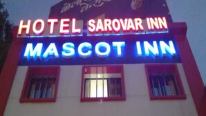 A building with a sign that reads "HOTEL SAROVAR INN MASCOT INN". - Hotel Sarovar Inn (Ahmedabad)