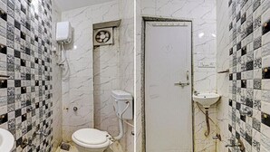 A bathroom with a toilet, sink, and shower. The walls are tiled with a black and white pattern. - Hotel Sarovar Inn (Ahmedabad)