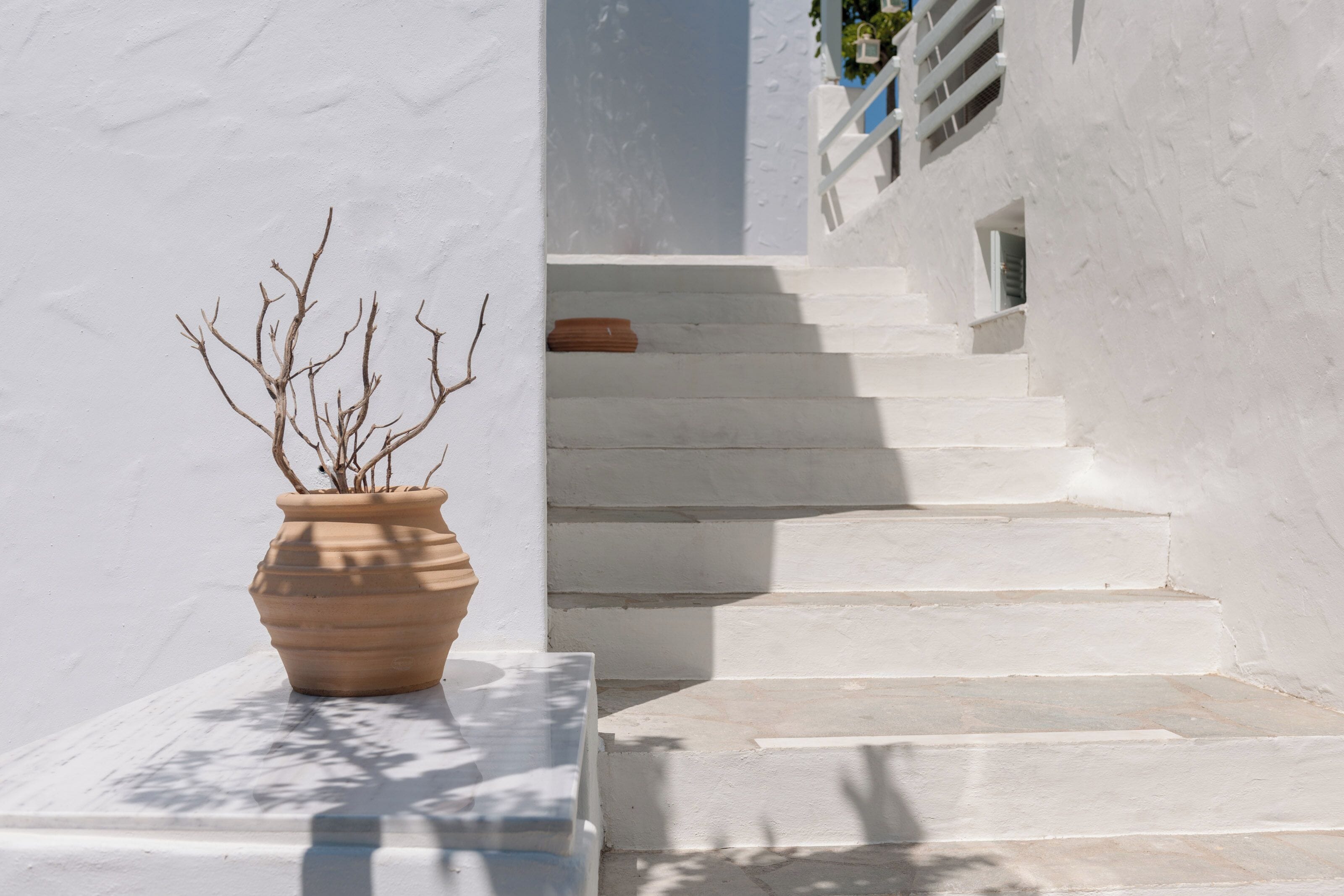 A white building with a staircase leading to a door.