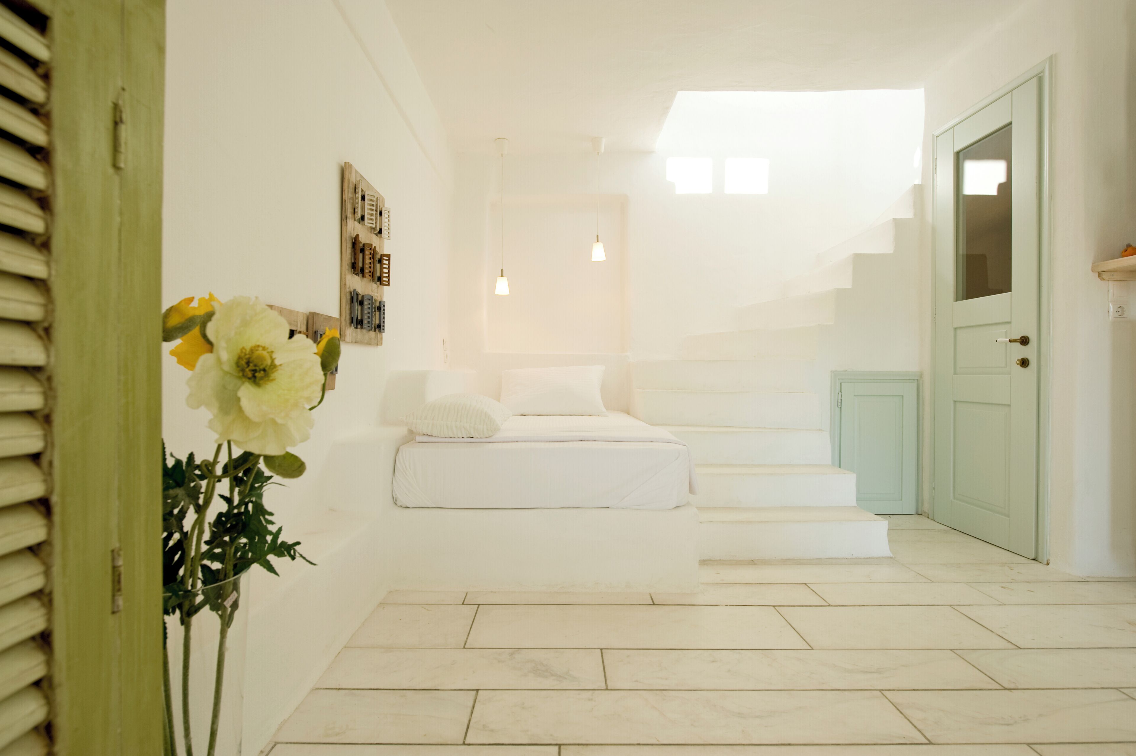 A staircase leading to a second floor, a white door, and a wall-mounted light fixture.