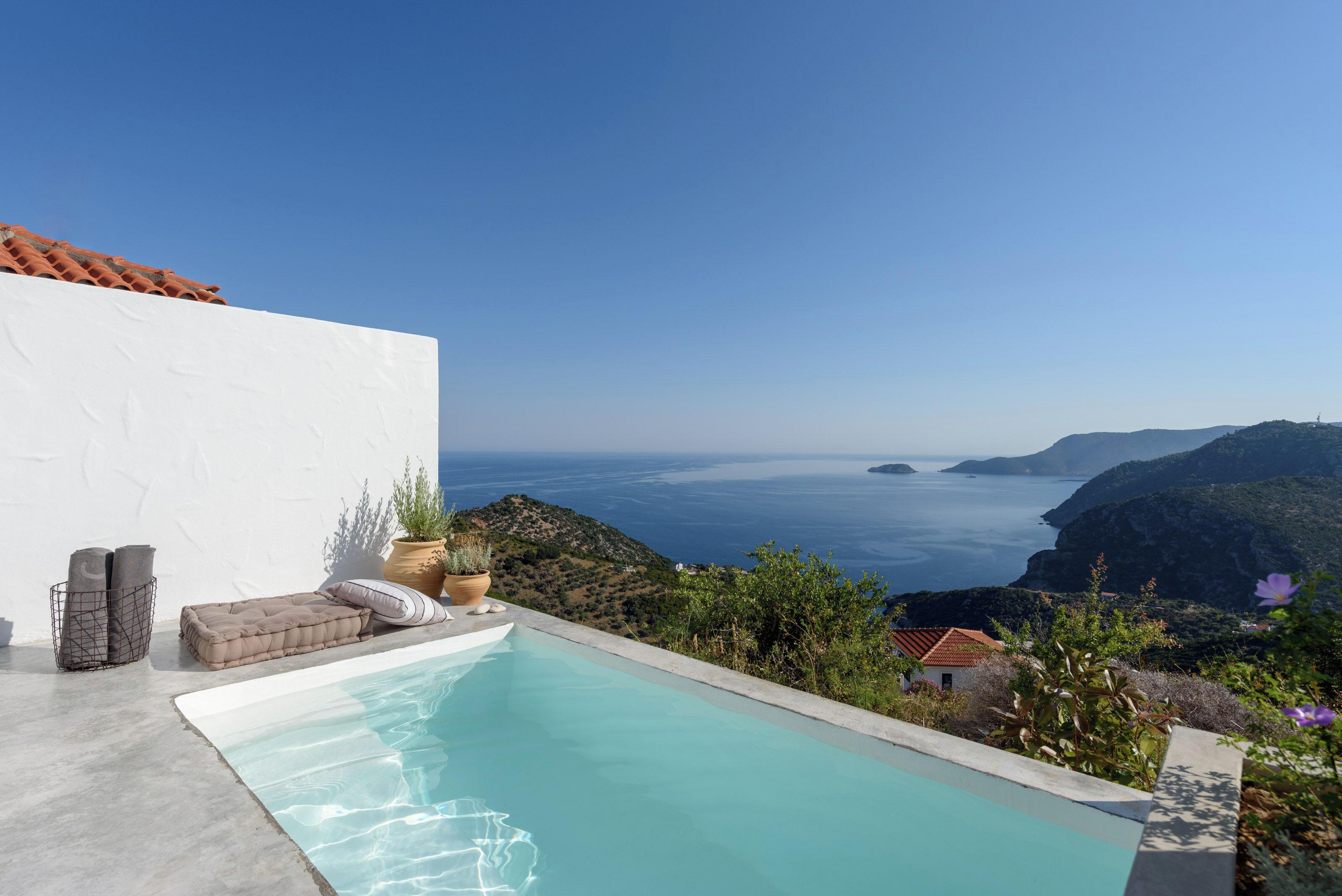 Piscina com vista desobstruída para o mar e colinas.