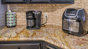 Eine Küche mit Kaffeemaschine, Toaster und einer Kapselhalterung.