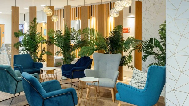 A modern lobby with blue armchairs, a grey armchair, and a round table. - For Students Only Skyline (Bournemouth)