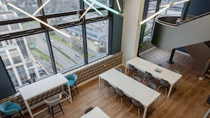 A modern office space with large windows, wooden flooring, and contemporary furniture. - For Students Only Skyline (Bournemouth)