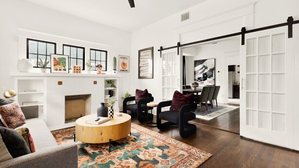 A modern living room with a fireplace, a dining area, and a large sliding door leading to another room. - La Flor: Family Dream Home ~ .5mi to Pearl ~ Pool (San Antonio)