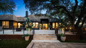 A modern house with a large front porch, steps leading to the entrance, and potted plants. - Hill Country Estate ~10 Acre Retreat~ Pool+Jacuzzi (Austin)