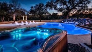 A hot tub area with a gazebo and lounge chairs.