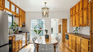A spacious kitchen with wooden cabinets, a large island, and a chandelier. - Haven de Luz: A Tranquil Retreat ~ Pool|Spa|Sauna (Austin)