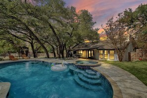A backyard with a swimming pool, a hot tub, and a covered patio area. - Austin Oasis: Pool, Pickleball, Hot Tub, Sleeps 10 (Austin)