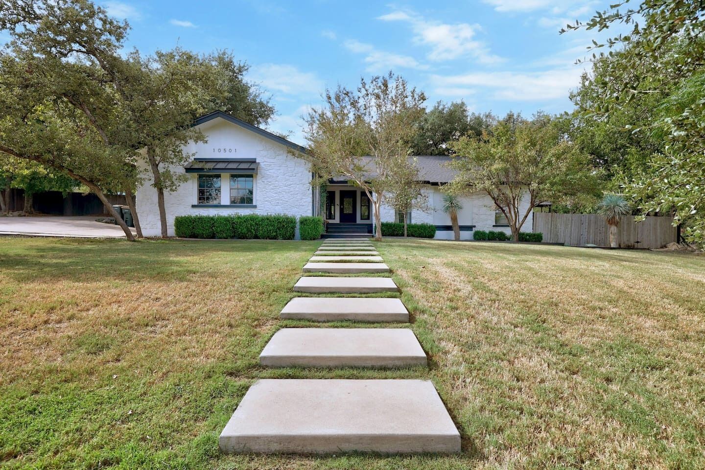 A house with a paved pathway leading to the front door.