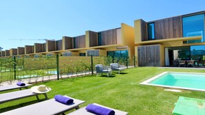 A modern building with a swimming pool, outdoor seating, and a well-maintained lawn. - Villa Essence by Clever Details, private pool, walk distance to the marina (Quarteira)