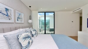 A modern bedroom with a large bed, a balcony with a glass door, and two framed abstract paintings on the wall. - Villa Essence by Clever Details, private pool, walk distance to the marina (Quarteira)