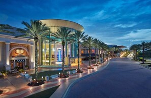 A hotel with a curved glass facade, palm trees, and a well-lit entrance. - Spacious Orlando Stay Free Wifi Game Room (Orlando)