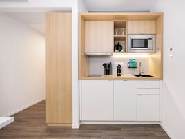 Eine moderne Küche mit Holzschränken, einer Mikrowelle und einer Kaffeemaschine.