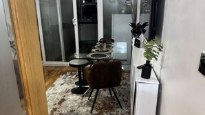 A modern kitchen with a dining area, wooden flooring, and a sliding glass door leading to a balcony. - Smethwick - House - Sleeps 8 - Parking (Smethwick)