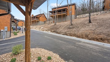 Un quartier résidentiel avec des maisons modernes en bois, une route asphaltée et un mur de soutènement en pierre.