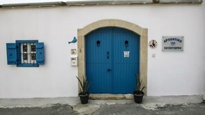 A blue door with a plaque, a blue window with shutters, and two potted plants. - Charming 3-bedroom Penthouse with AC, WiFi in lovely Oroklini (Oroklini)