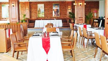 Un restaurante con paredes de ladrillo, sillas y mesas de madera dispuestas para comer.