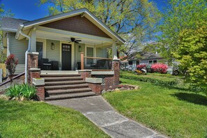 A two-story house with a front porch, brick steps, and a small garden. - Les Petit Maison (Black Mountain)