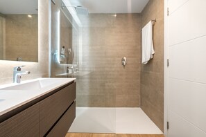 A modern bathroom with a large mirror, a shower, and a vanity with a sink. - AL4-2107 ESTEPONA - APARTMENT - ALCAZABA LAGOON (Casares)