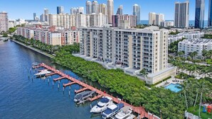 A high-rise hotel with a marina, docked boats, and a pool. - Le Petit Italie Water View 2 2 With Pool (Sunny Isles Beach)
